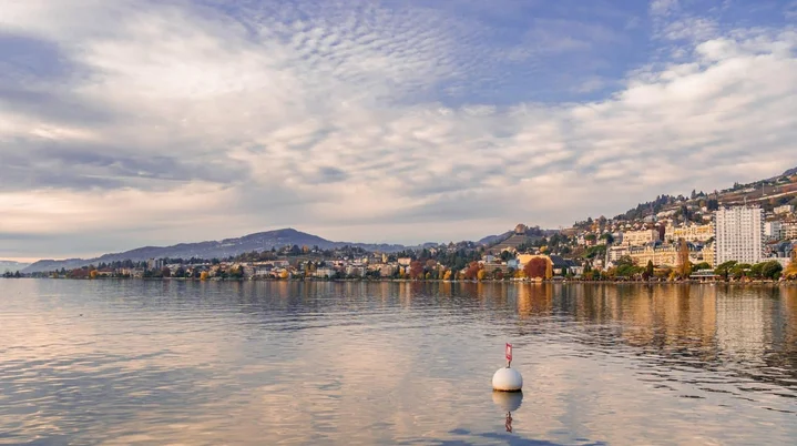 Scenic view of Montreux on Lake Geneva with the Swiss Alps in the background, representing a cannabis travel experience in Switzerland